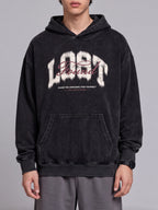 Front view of a black Lost & Found washed hoodie with a chest graphic and kangaroo pocket.