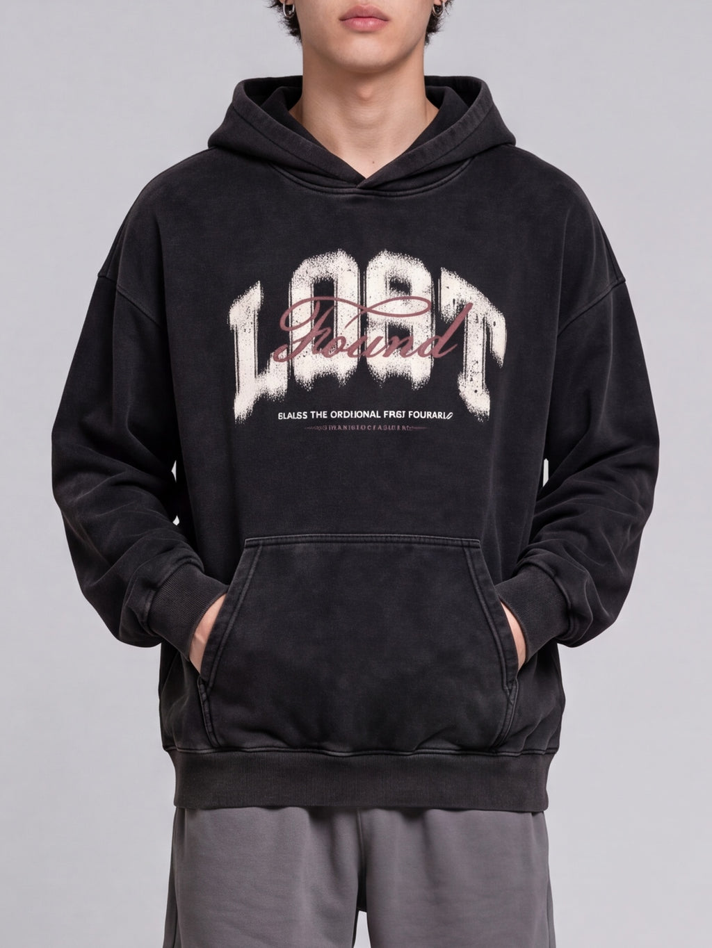 Black Lost & Found washed hoodie shown from the front with hands in the kangaroo pocket.
