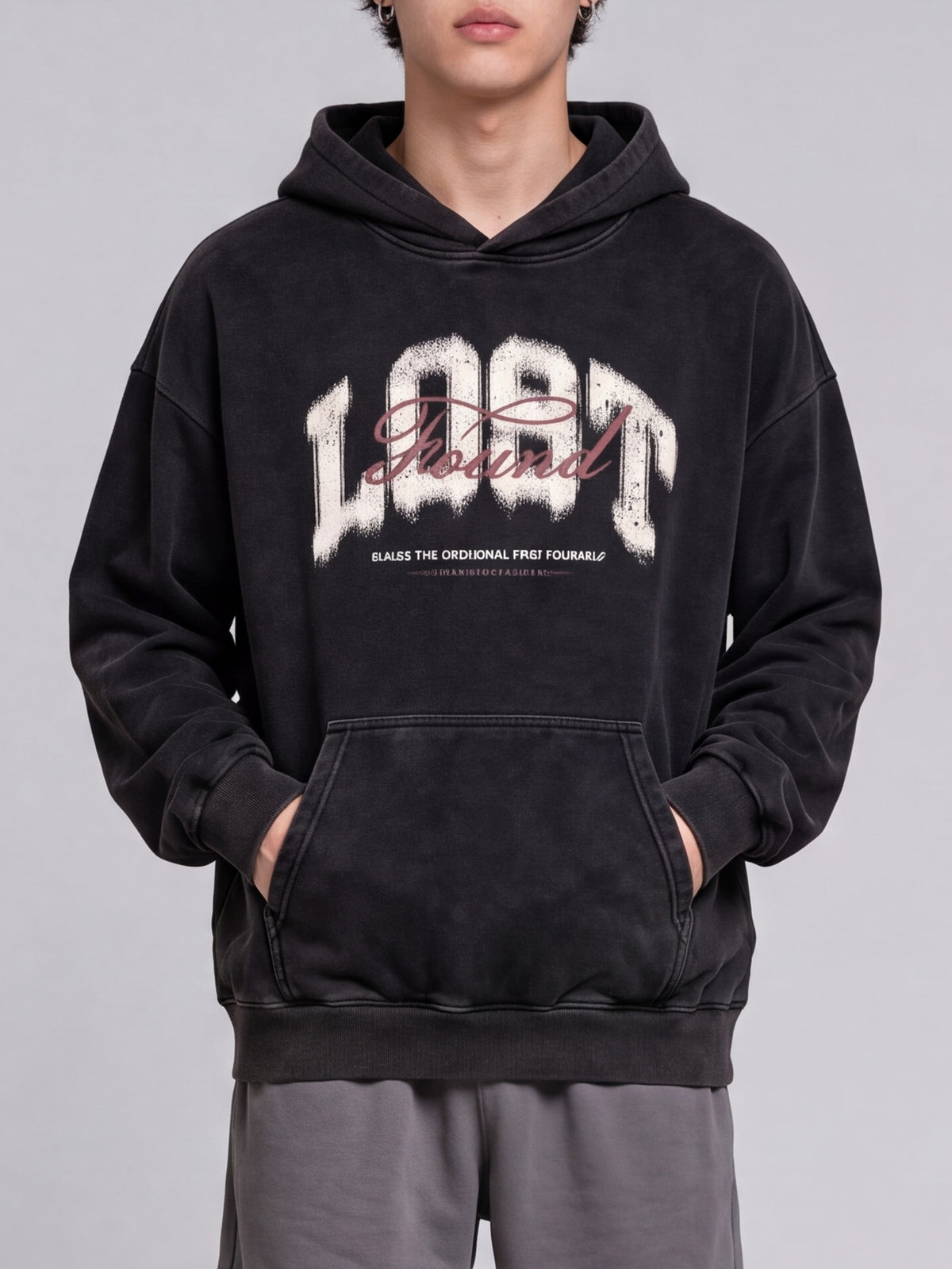 Black Lost & Found washed hoodie shown from the front with hands in the kangaroo pocket.