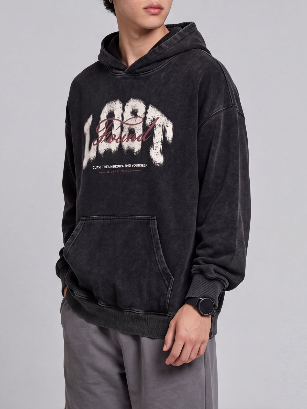 Side-angle view of a black Lost & Found washed hoodie, showing the roomy sleeves and ribbed cuff.