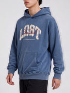 Side-angle view of a blue Lost & Found washed hoodie, showing dropped shoulders and a ribbed hem.