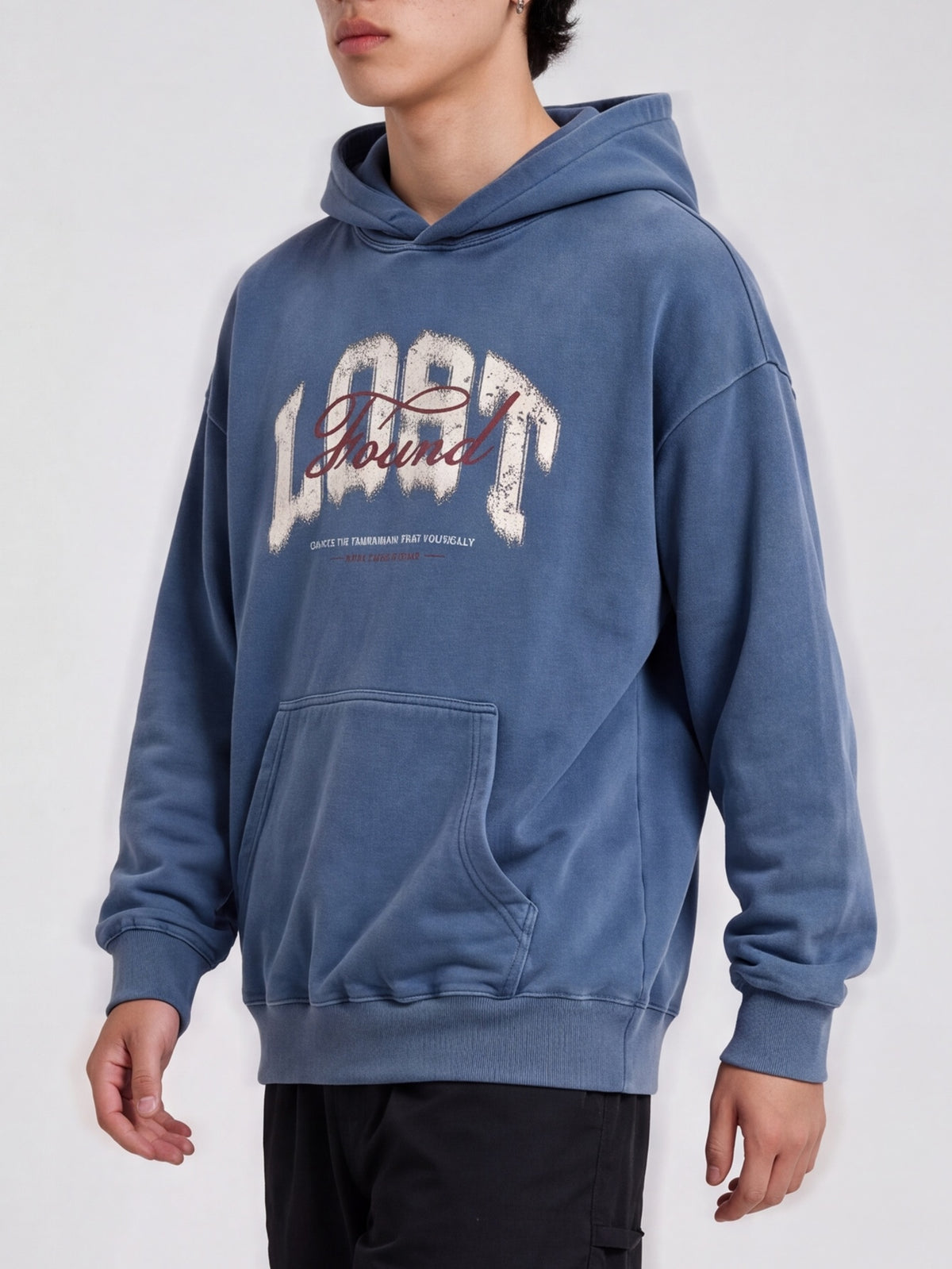 Side-angle view of a blue Lost & Found washed hoodie, showing dropped shoulders and a ribbed hem.