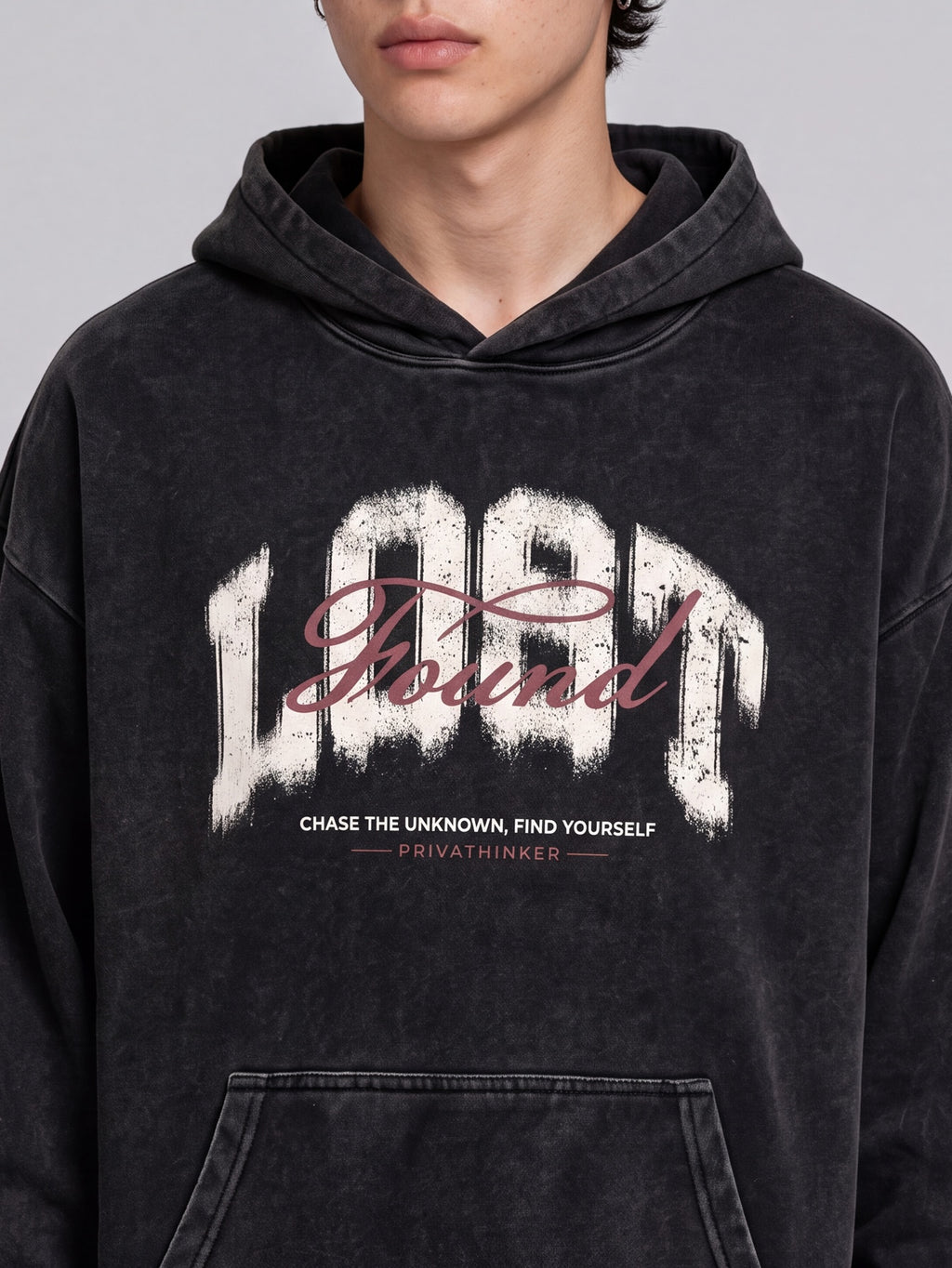 Close-up of the distressed Lost & Found chest graphic on a black washed hoodie.